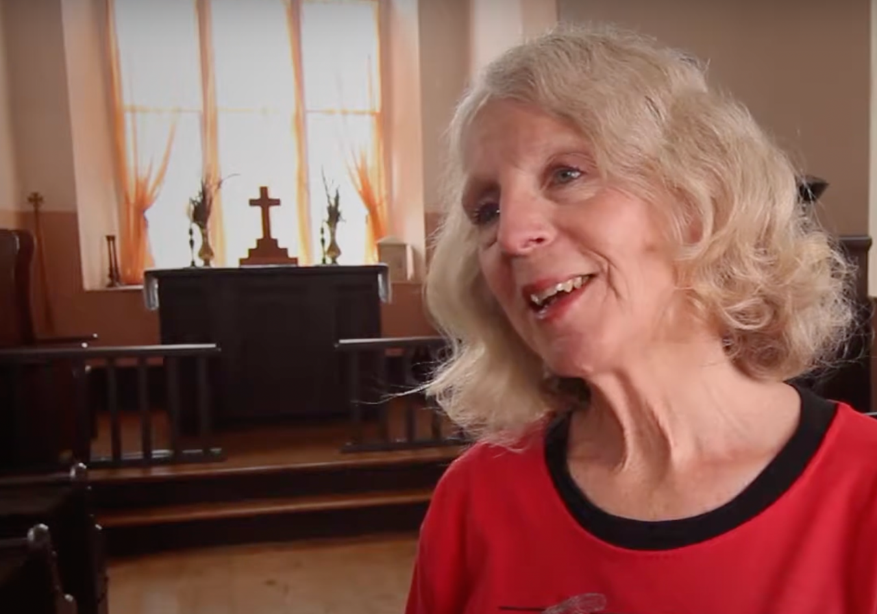 older woman talking in a chapel