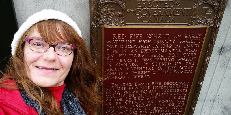 girl taking a picture with historical plaque