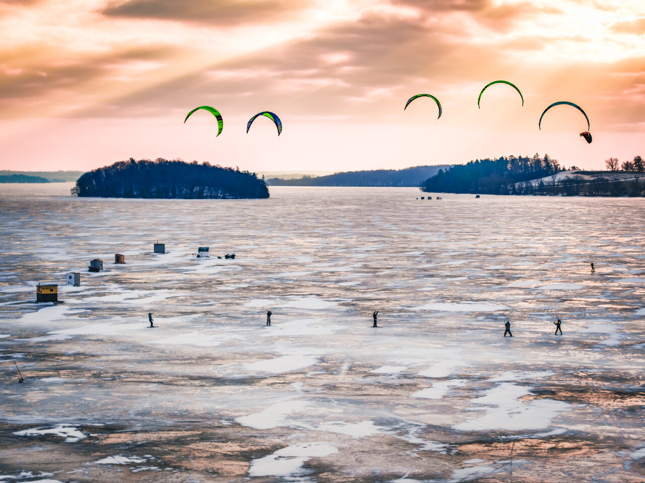 winter sunset over frozen Rice Lake with 5 people snow kiting
