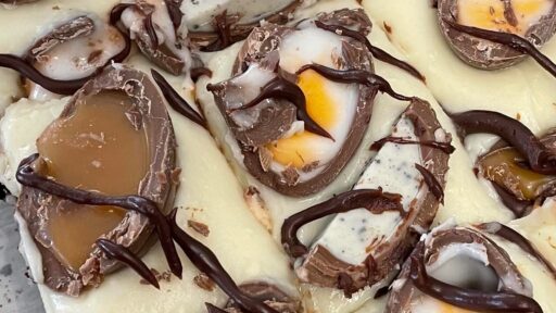 Cream egg brownie, white chocolate with broken up cream eggs, drizzled with chocolate sauce