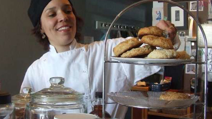 a pastry chef adding pastries to a tray