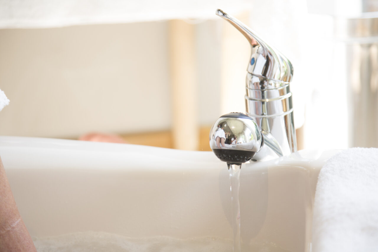 close-up of faucet filling up a foot bath
