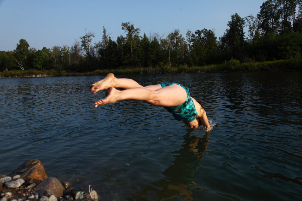 girl diving into lake 