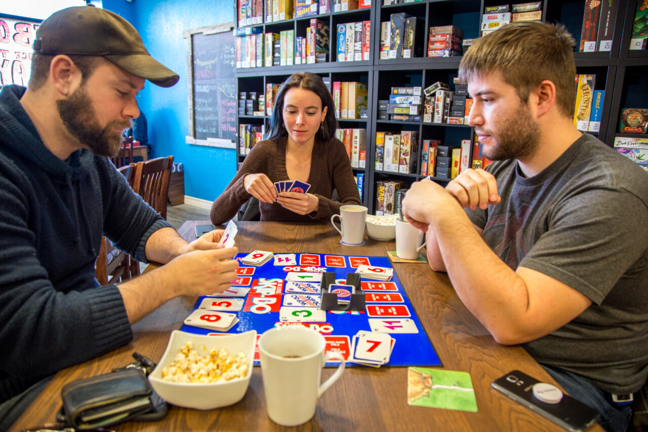 three people playing a card game