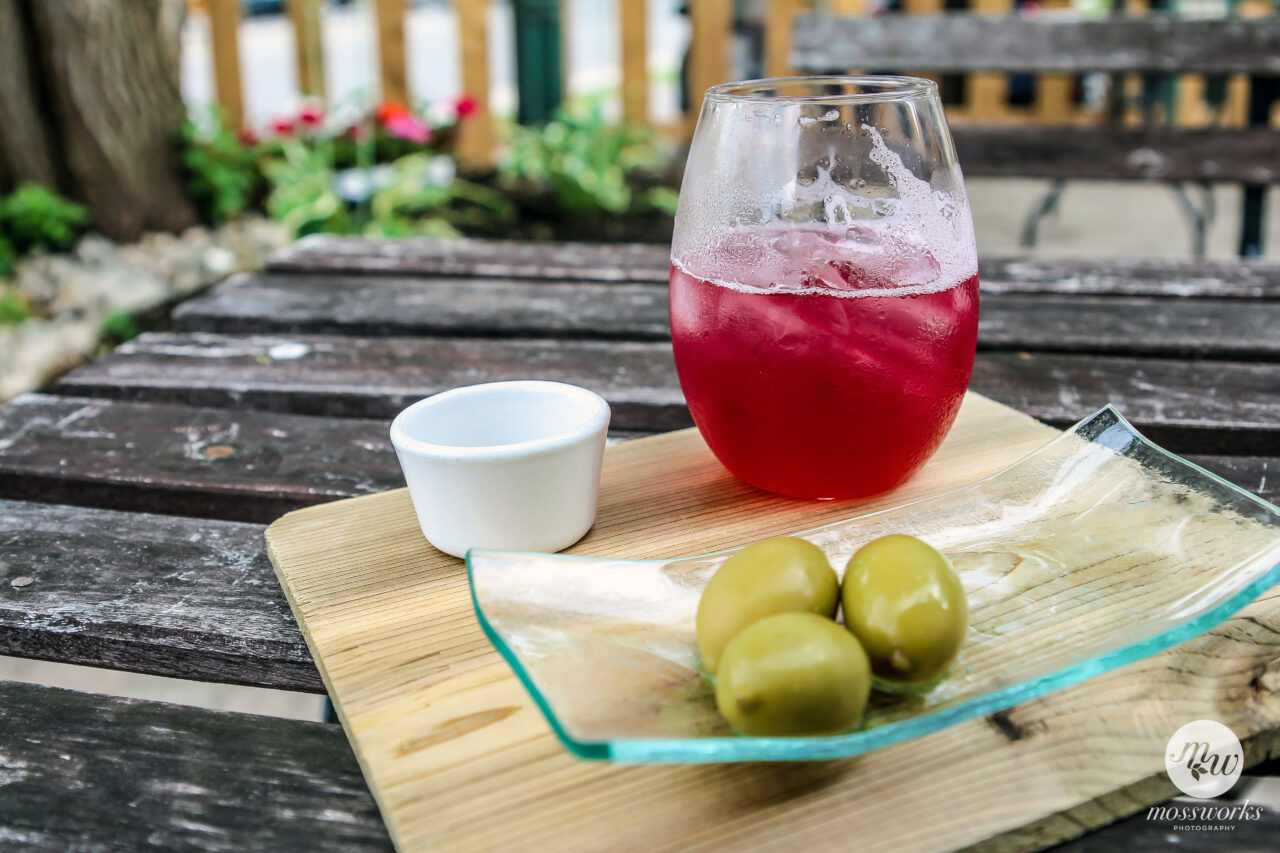 cold drink and olives on cutting board