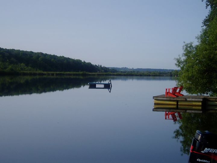 lake with chairs on a dock and a floating dock