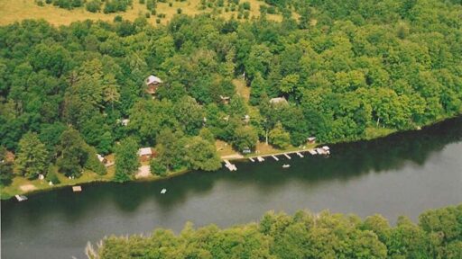 Birds eye view of a cottage resort on a lake with forests