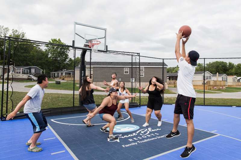 a group of young people playing basketball on an outdoor court
