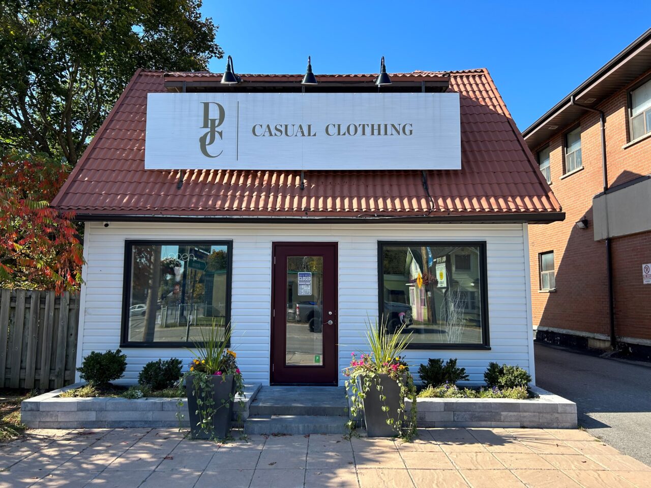 White building, brown roof with a large sign that says "DJC Casual Clothing" - Dan Joyce Clothing Apsley location.
