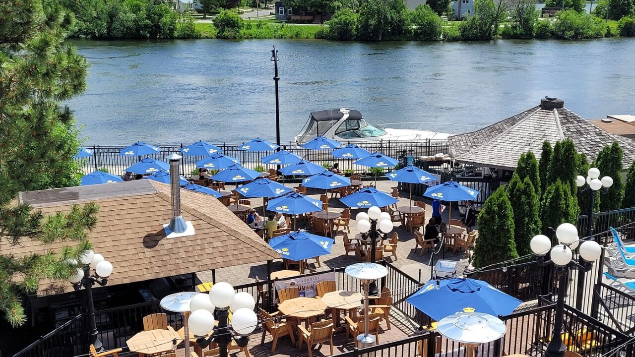 Overlooking waterfront patio tables with blue umbrellas
