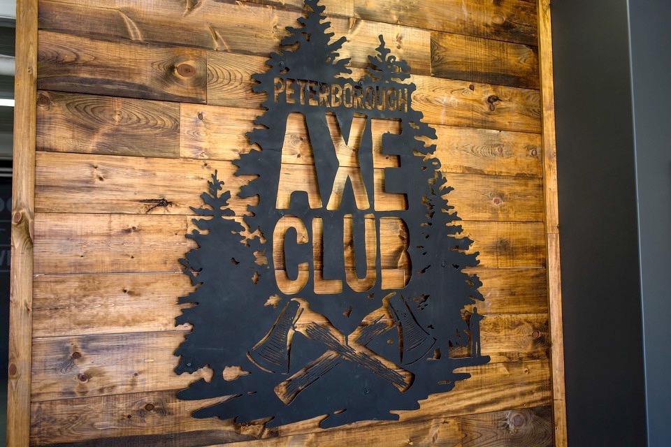 Peterborough Axe Club sign on rustic wooden wall