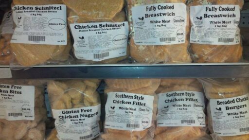 the photo consists of four row shelves in a freezer. The top shelf has chicken tenders and chicken strips. The second row has chicken schnitzel and fully cooked chicken breastwich. The third row down has gluten free chicken nuggets, southern style chicken fillets, and breaded chicken burgers. The bottom shelf has breaded chicken balls and buffalo style chicken strips.
