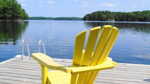 yellow chair on dock, on a lake