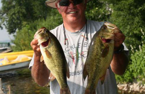 smiling man holding two fish