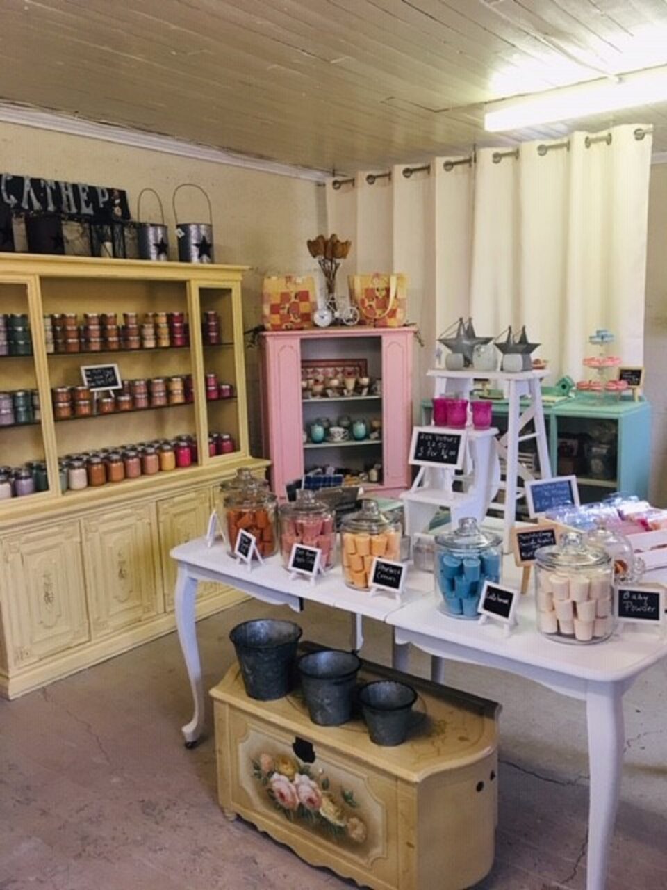Shelves and tables in a boutique displaying candles and other things for sale