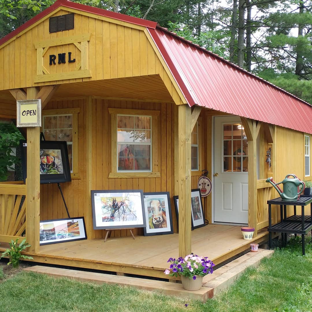 outside of wood cabin with art on display