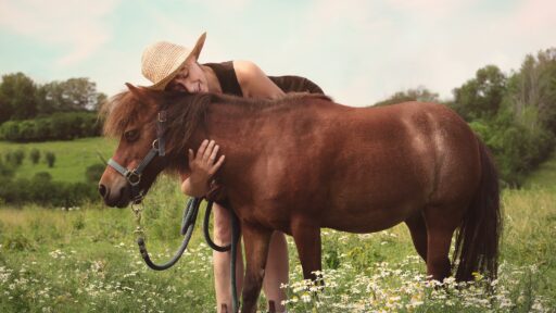 a lady hugging a pony