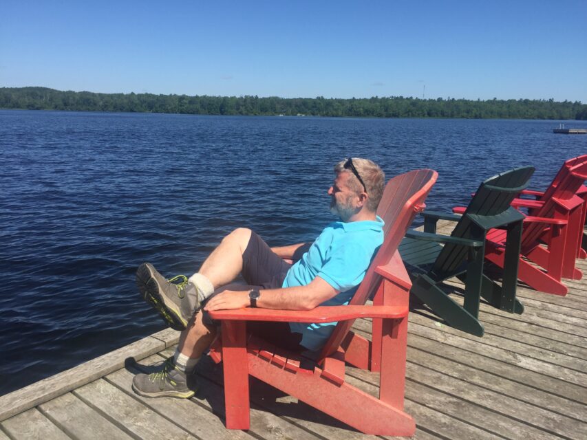 guy sitting in a red char on a dock
