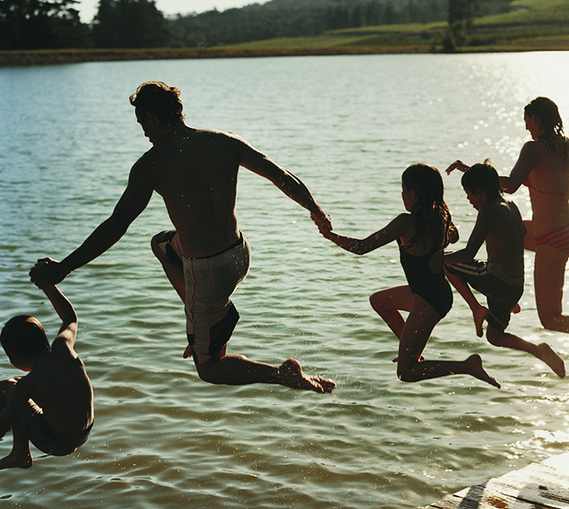 family jumping into lake