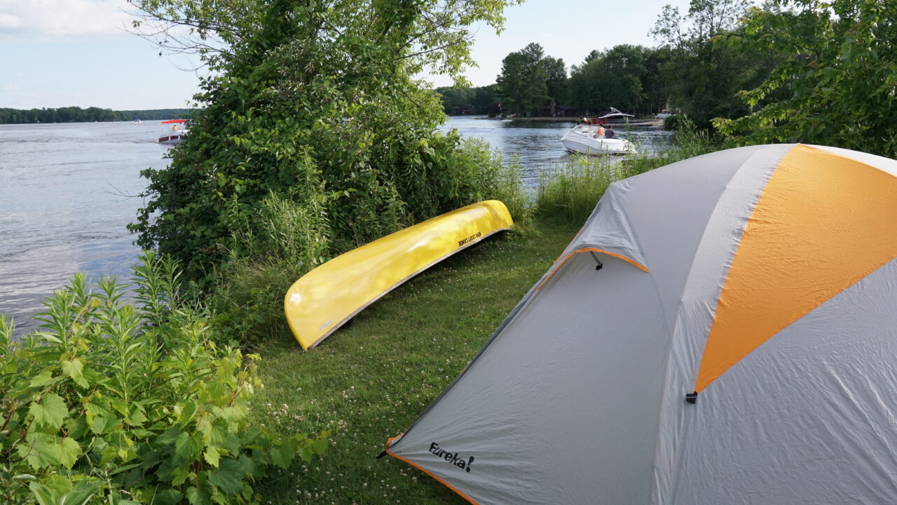 a tent and canoe by a lake