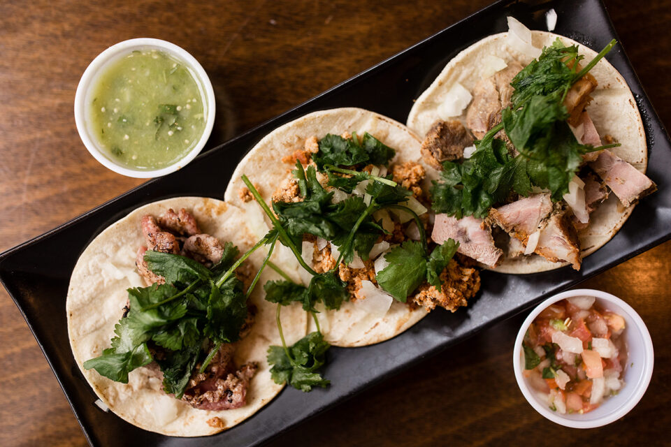 Taco trio on tray served with salsa and verde salsa