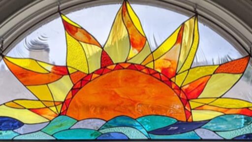 a stained glass piece of the sun over water