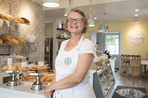 woman in an apron standing in a bakery