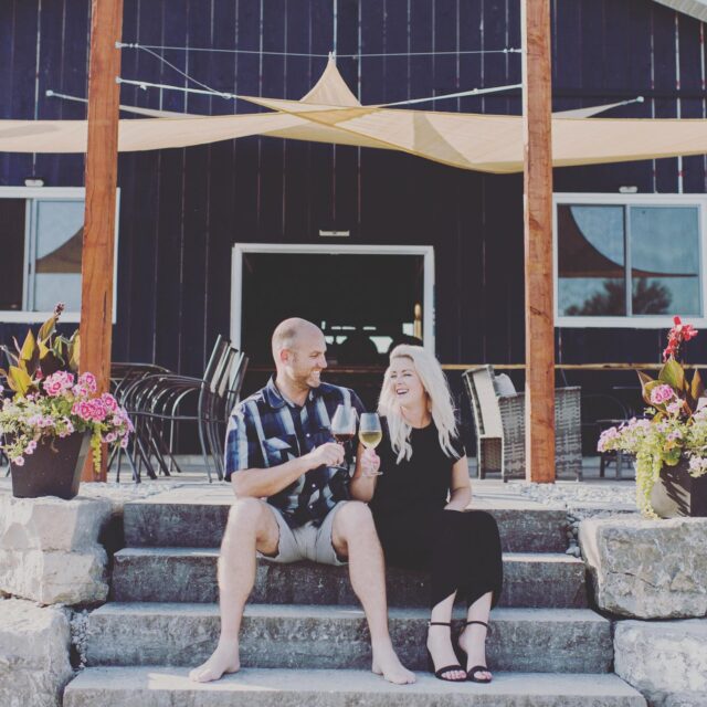 a couple drinking wine on a step