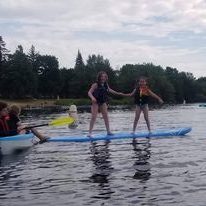 two kids standing on kayak