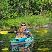 woman in kayak with dog in a lake during the summer in Peterborough & the Kawarthas