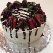 white cake with strawberries and chocolate sauce