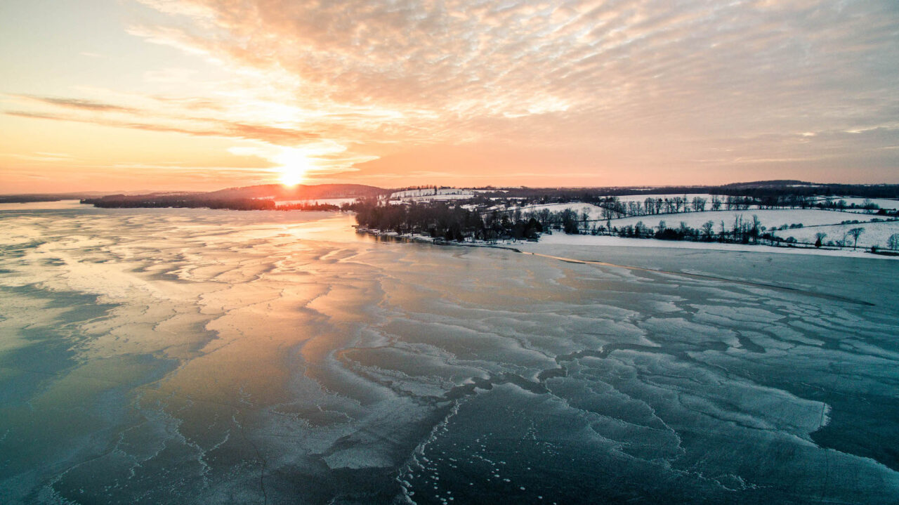 a frozen lake at sunset