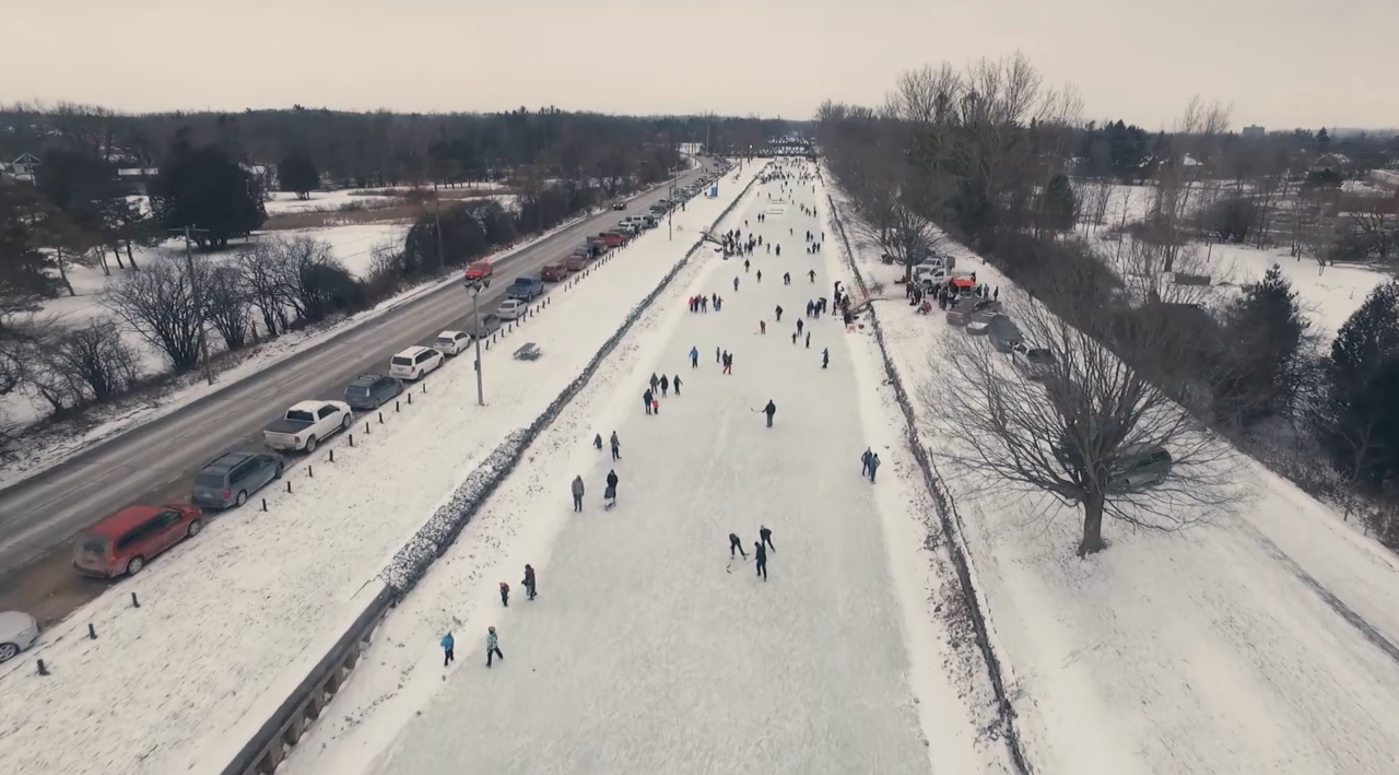 aerial view of a frozen canal with people skating