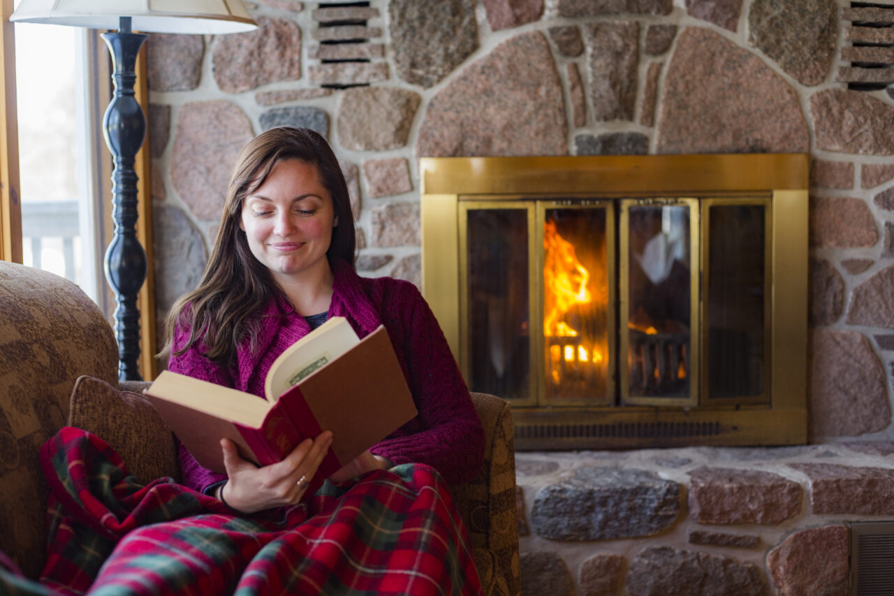 woman reading by the fire