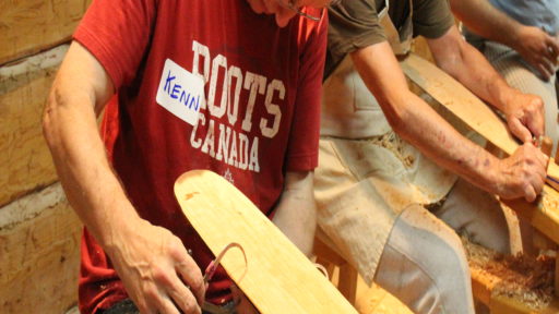 a person carves a piece of wood