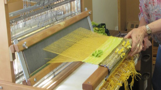 A person works on a loom