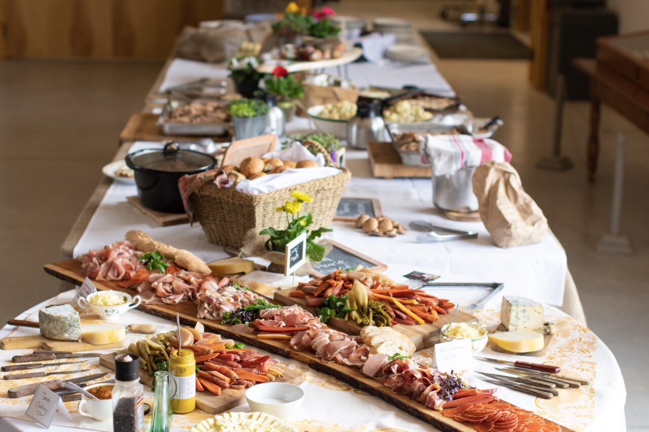 A table covered in bread, meat, and vegetables on plates