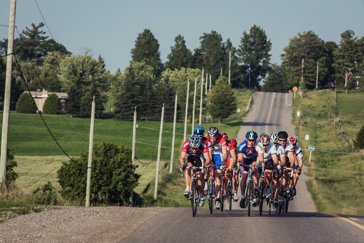a group of cyclist on a country road