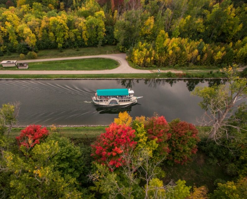 A boat causing down a river in the fall