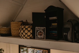a shelf showing baskets and books