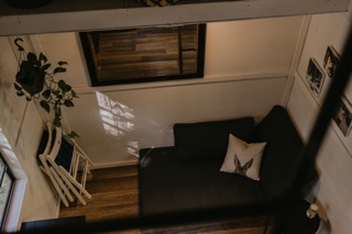 an aerial view of a living space in a tiny house with a couch and window