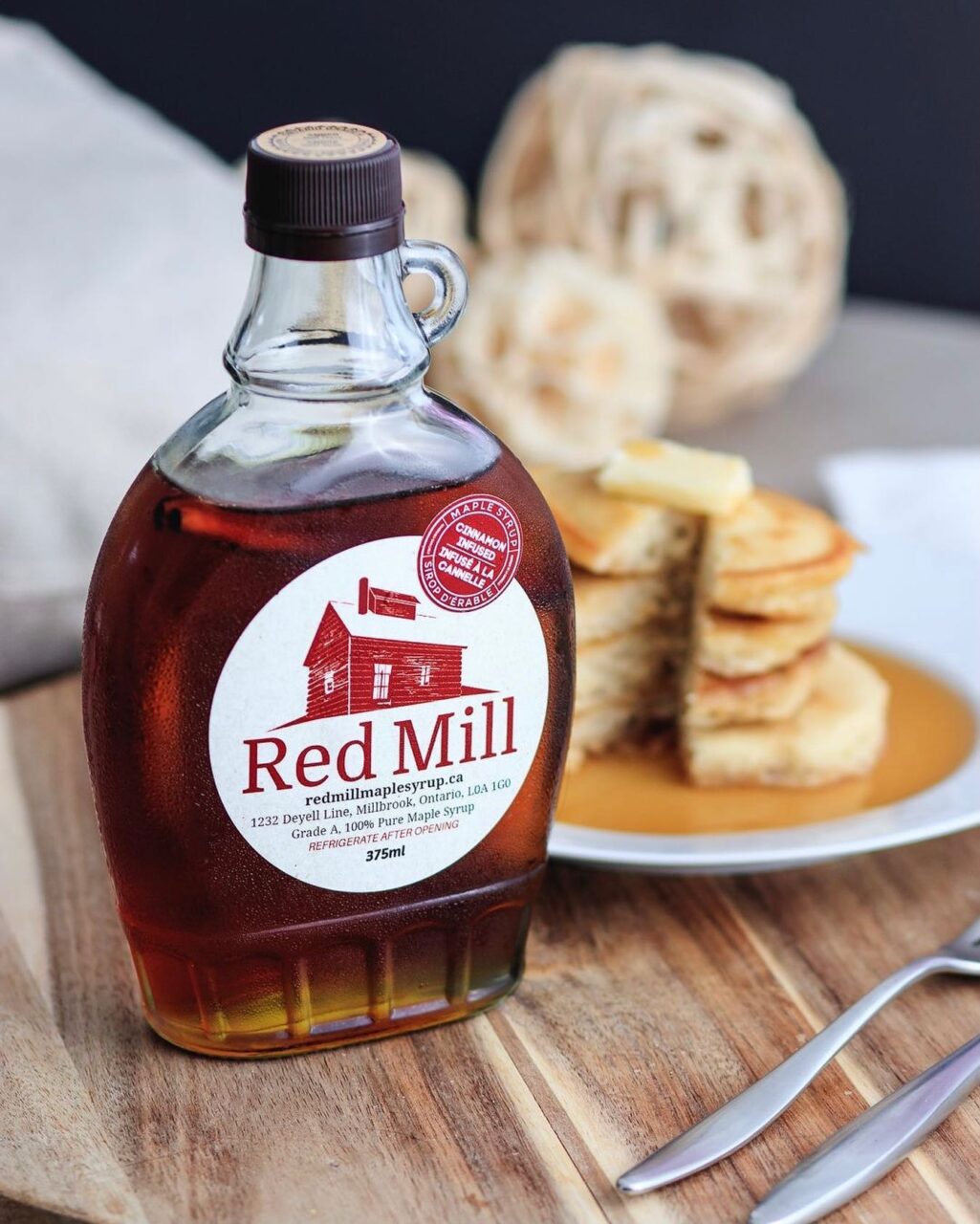 a bottle of maple syrup on a table with pancakes