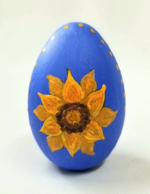 blue egg painted with yellow sunflower