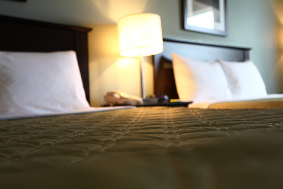 wide angle shot of hotel beds with lamp between at Super 8 Peterborough