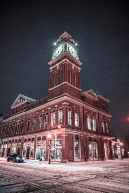 a photo of a building with a clock tower, at night, during winter