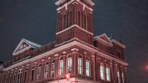 a photo of a building with a clock tower, at night, during winter