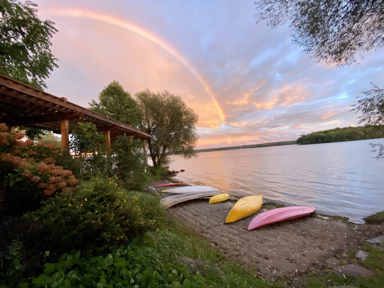 Sunset at Elmhirst Resort on the lake with kayaks on the ground