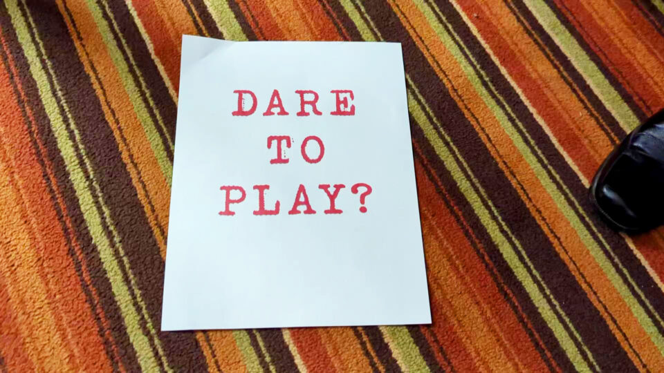 white paper with red writing "Dare to Play?"