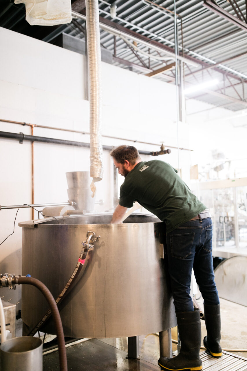 a man working in a large beer fermenter