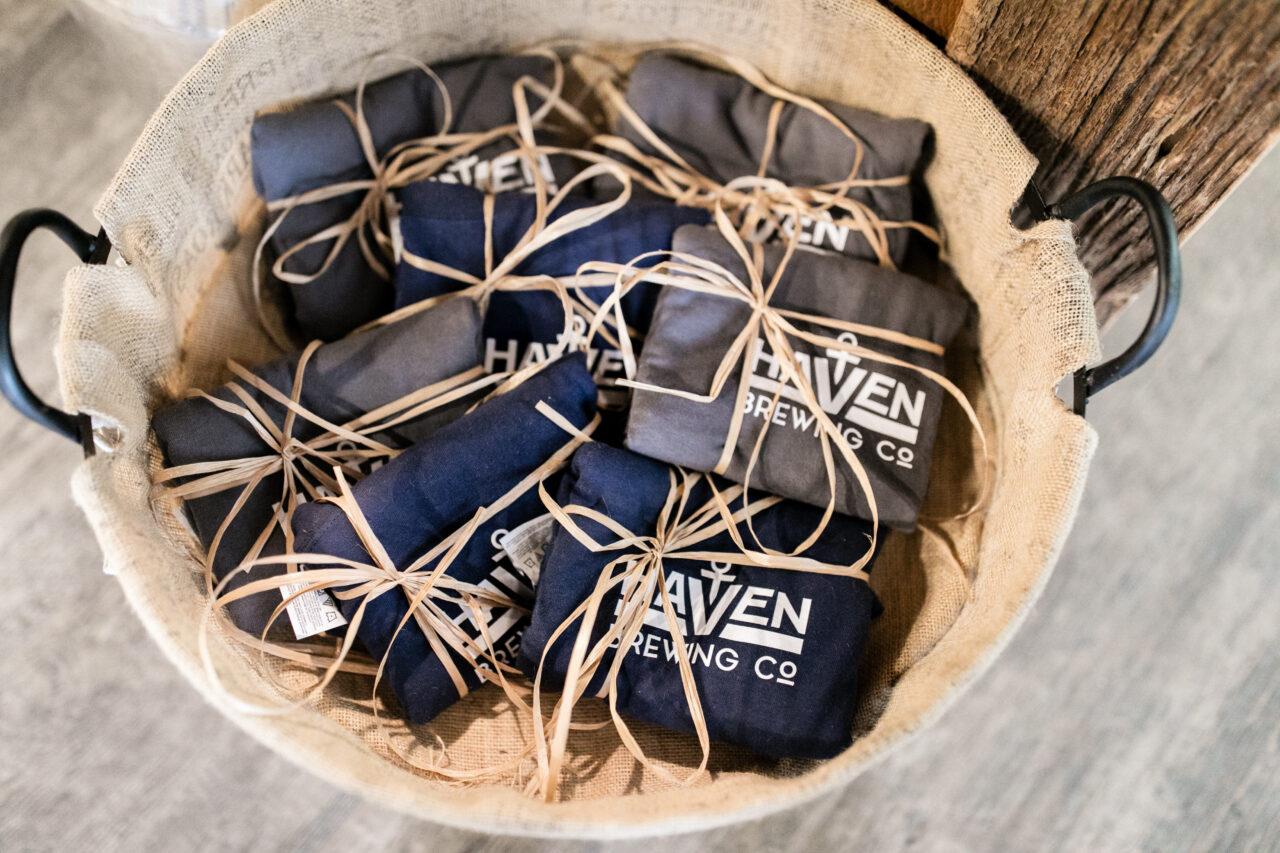 a basket filled with t-shirts wrapped up. havens brewing company written on the shirts